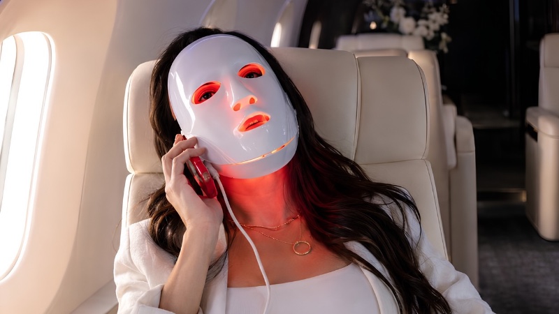 Guest using LED light therapy mask onboard a Jettset cabin