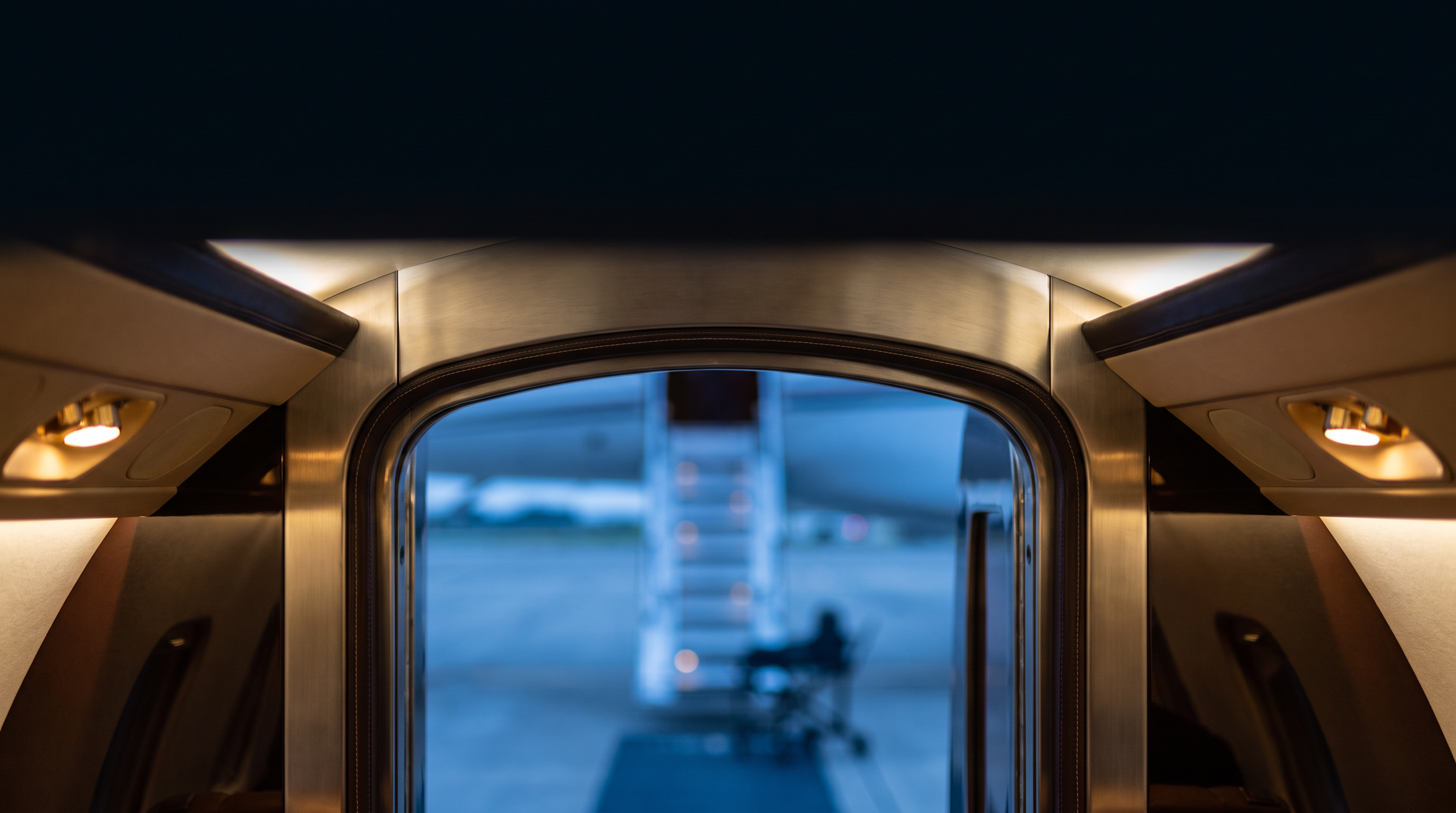 Aircraft cabin doorway opening onto the tarmac, representing the continuity of a bed-to-bed medical transfer.